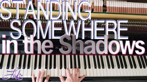 standing somewhere in the shadows.